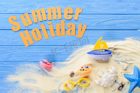 沙滩玩具在蓝色木质背景下的夏日假期题词