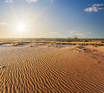 城市摄影照片_炎热的夏季沙质沙漠景观在日落