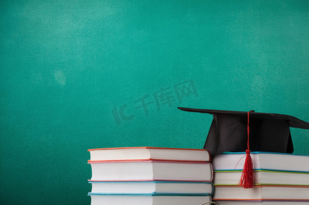 毕业摄影照片_书堆和毕业帽放在桌上