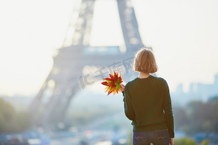美丽的年轻法国妇女与一串五颜六色的秋天叶子在巴黎埃菲尔铁塔附近在秋天天