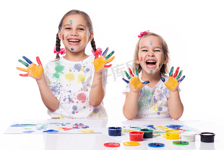 油漆背景摄影照片_两个小女孩玩手指油漆的肖像