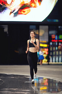 培训冲刺摄影照片_运动的女孩跑在街道与夜城市 baclkground