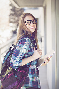 背包站立的女孩拿着书本微笑