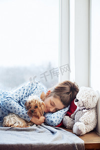 敢想敢做敢做梦摄影照片_快乐的女孩睡在窗台上。圣诞节的概念.