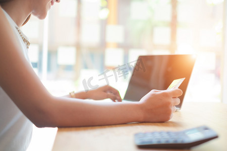 天猫淘宝618摄影照片_美丽的女人拿着信用卡使用笔记本电脑享受网上购物网站,购物自负