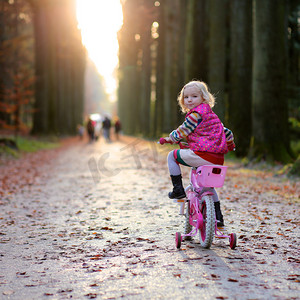 春天摄影照片_在森林或公园享受阳光明媚的一天的小女孩