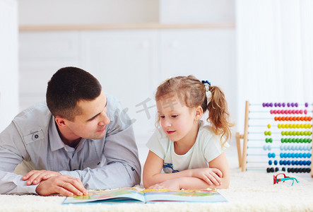 快乐的父亲和女儿相处时间，将阅读有趣的书