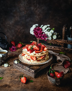 奶油的摄影照片_有新鲜草莓和奶油奶酪在木板上的蛋糕，季节性甜点