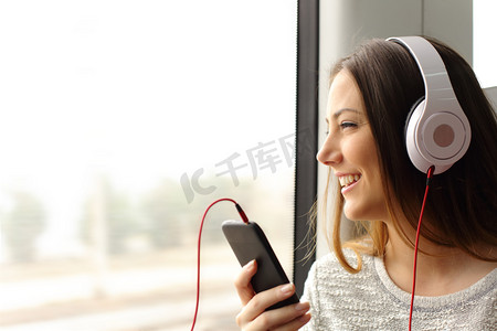 青少年乘客听音乐在火车旅行