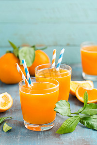 橙汁在玻璃和新鲜水果与叶对木制背景