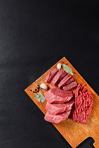 黑色背景摄影照片_新鲜的肉切肉分类在黑色背景上