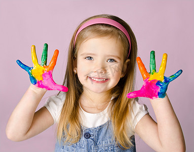 brincando摄影照片_微笑着用手在油漆的小女孩