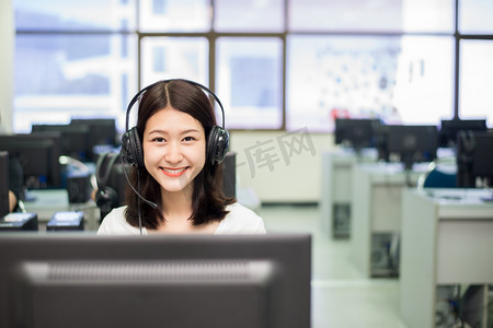 微笑亚洲女学生在学习的同时与计算机合影