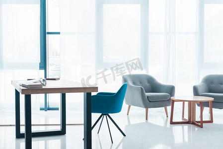 内部办公摄影照片_木桌和空舒适的扶手椅在现代办公室内部