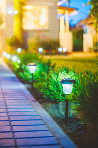绿色灯泡摄影照片_太阳能庭院灯，灯笼在花床上。花园设计