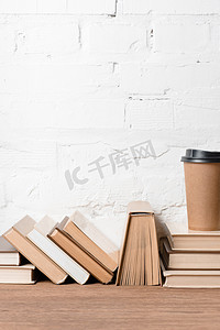 服装产品信息摄影照片_木桌上的书籍和一次性咖啡杯