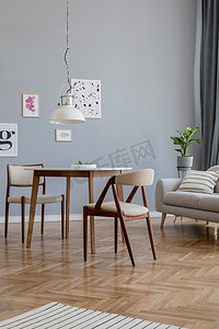 设计斯堪的纳维亚家居内部的开放空间与时尚的椅子，家庭表木制commode，灰色的床，配件和模拟海报画廊墙。灰色背景墙。复古舒适的家居装饰. 