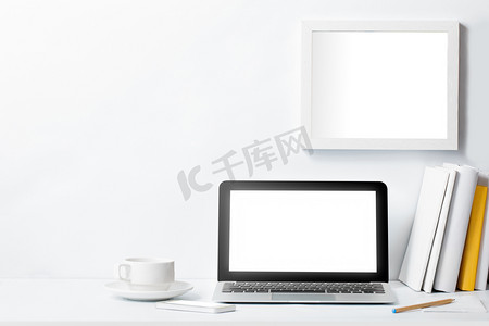 工作区桌面摄影照片_笔记本电脑上案头工作和白墙上的帧