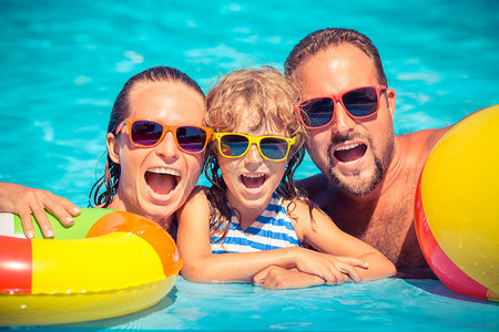 幸福的家庭在游泳池玩