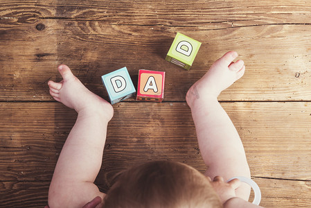 Little baby with cubes and  dad sign