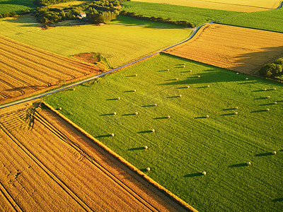 夏天摄影照片_从空中俯瞰法国布列塔尼的牧场和农田。美丽的法国乡村,绿油油的田野和草地.日落时分的乡村风景