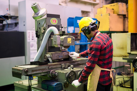 公制摄影照片_工厂机械专业工人与头盔和玻璃工作的漆树金属生产五金.自动化机械背景重工业安全第一.