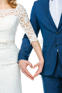婚礼夫妇的部分视图显示的心的符号双手一起隔离在白色