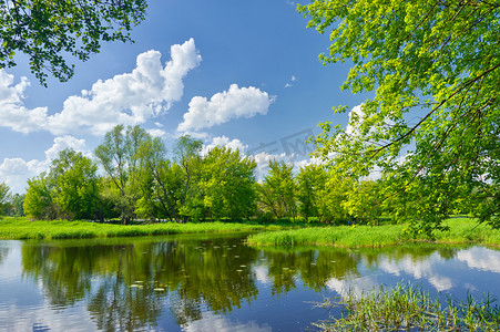 明媚春天摄影照片_夏天春天景观与 narew 河和蓝蓝的天空上的云
