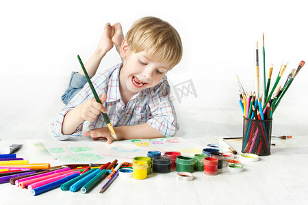 create摄影照片_Happy child drawing with brush by multicolor paints