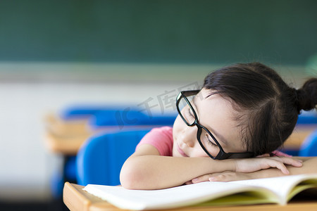 小女孩睡在教室里戴着眼镜