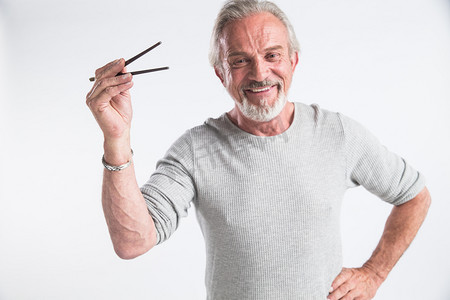 男人肖像摄影照片_老年男人拿着筷子