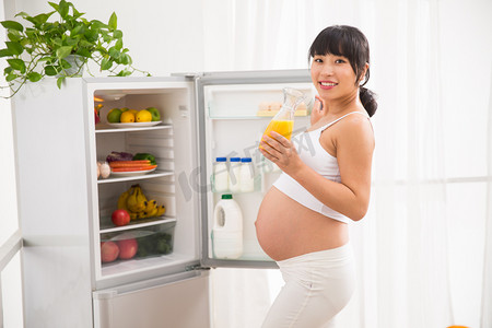 孕妇打开冰箱拿果汁