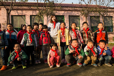 志愿者队旗摄影照片_乡村教师和小学生在学校里