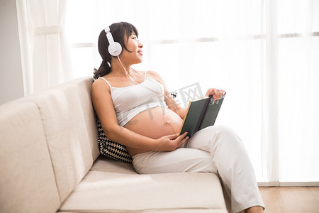 听歌看书商务摄影照片_孕妇听音乐看书