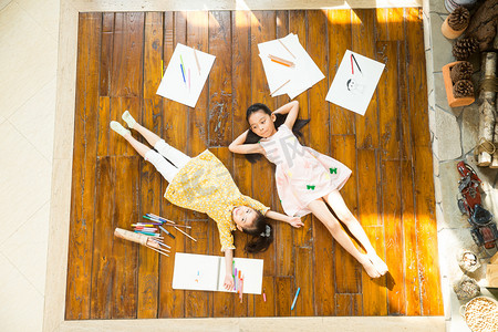 姐妹俩躺在地板上玩耍