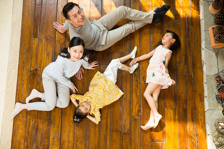 躺着的人像摄影照片_幸福家庭躺在地板上