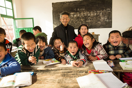 贫穷乡村摄影照片_乡村男教师和小学生在教室里