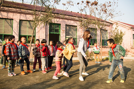乡村教师和小学生在学校里做游戏