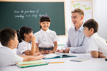 黑板指导摄影照片_教师和小学生在教室里