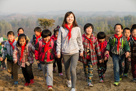 可爱奔跑摄影照片_乡村女教师和学生在玩耍