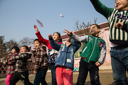 乡村小学生在学校放纸飞机