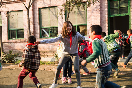 嬉戏摄影照片_乡村教师和小学生在学校里做游戏