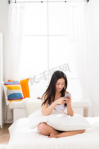 青年女人在卧室用手机