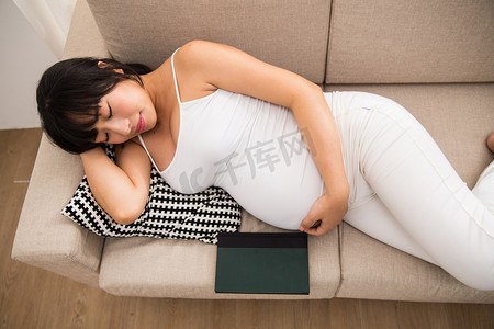 躺着休息摄影照片_孕妇躺在沙发上睡觉