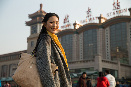 春运摄影照片_青年女人在站前广场