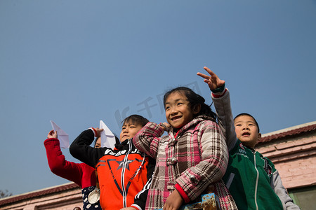 红领巾摄影照片_乡村小学生在学校放纸飞机