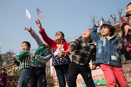 纸飞机飞机摄影照片_乡村小学生在学校放纸飞机