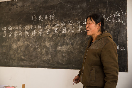 学习小黑板摄影照片_乡村女教师在教室里