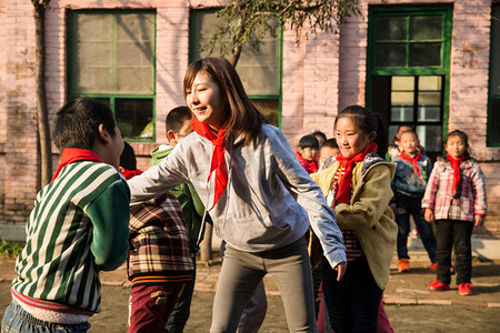 红领巾奖争章摄影照片_乡村教师和小学生在学校里
