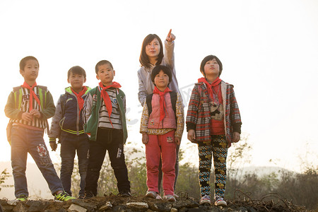 亚洲男孩摄影照片_乡村女教师和学生在户外
